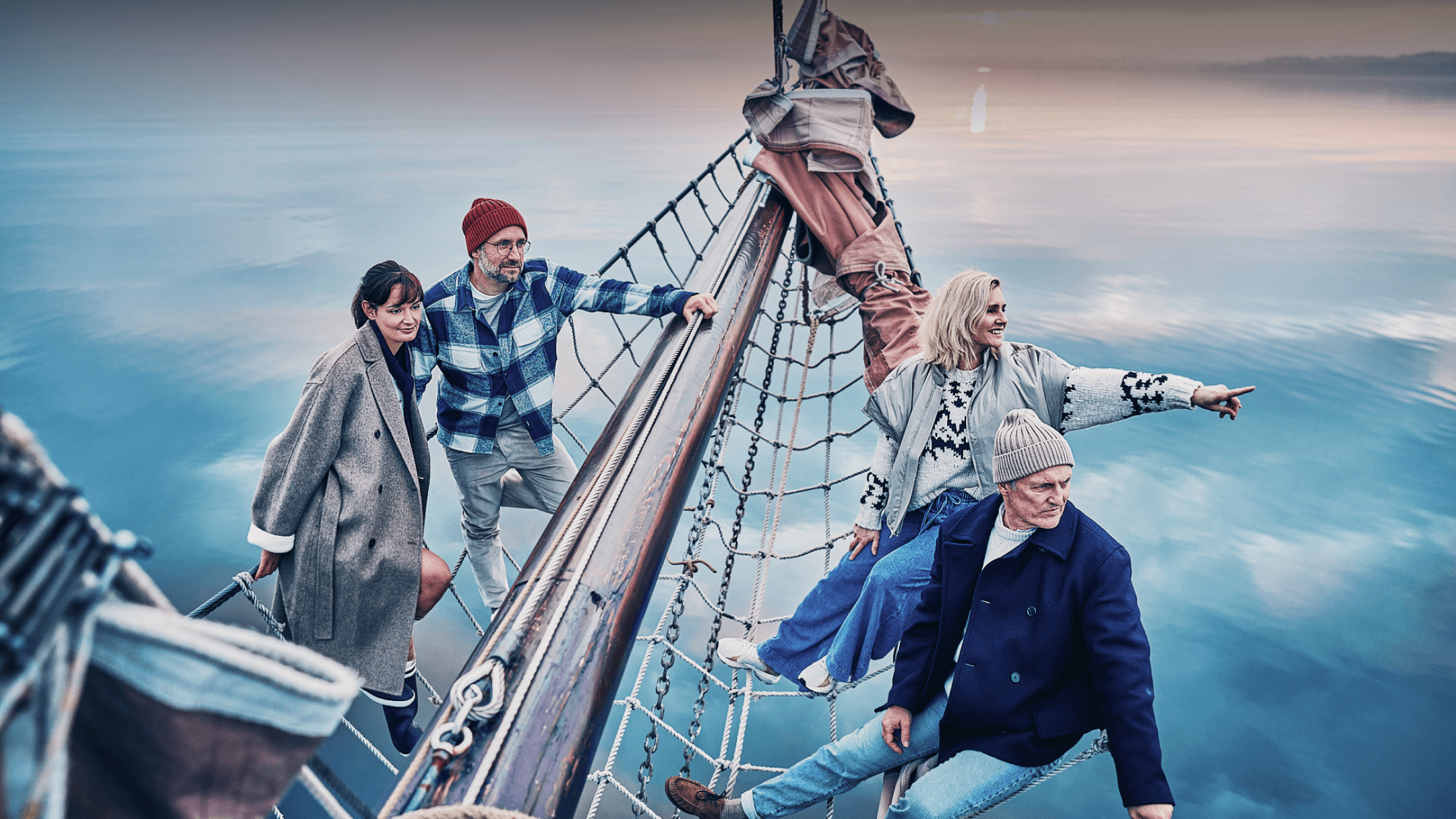 Die Partner von HADLEY an Bord eines Segelschiffs, gemeinsam auf das offene Wasser blickend.